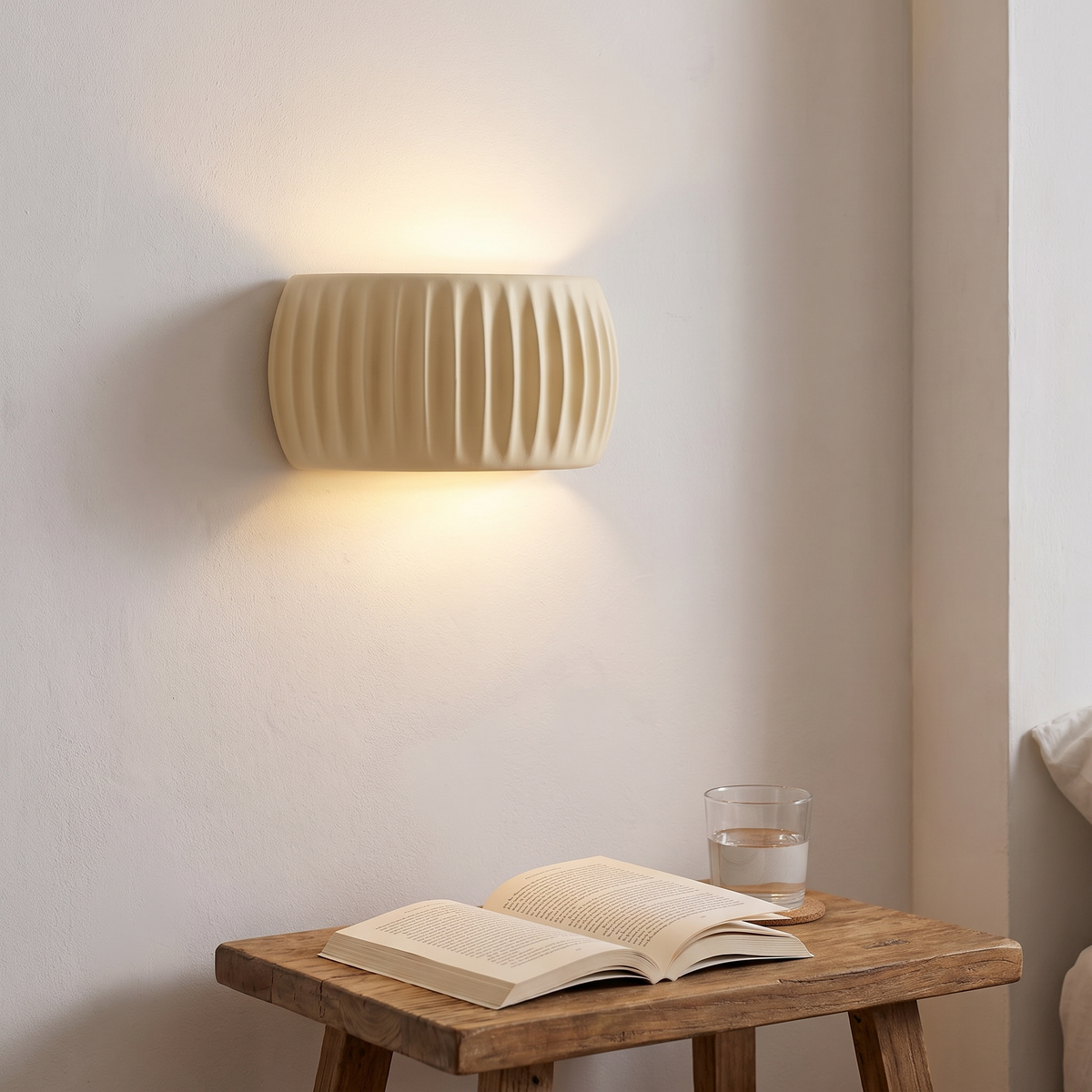 French Resin Wall Lamp lit above a bedside table